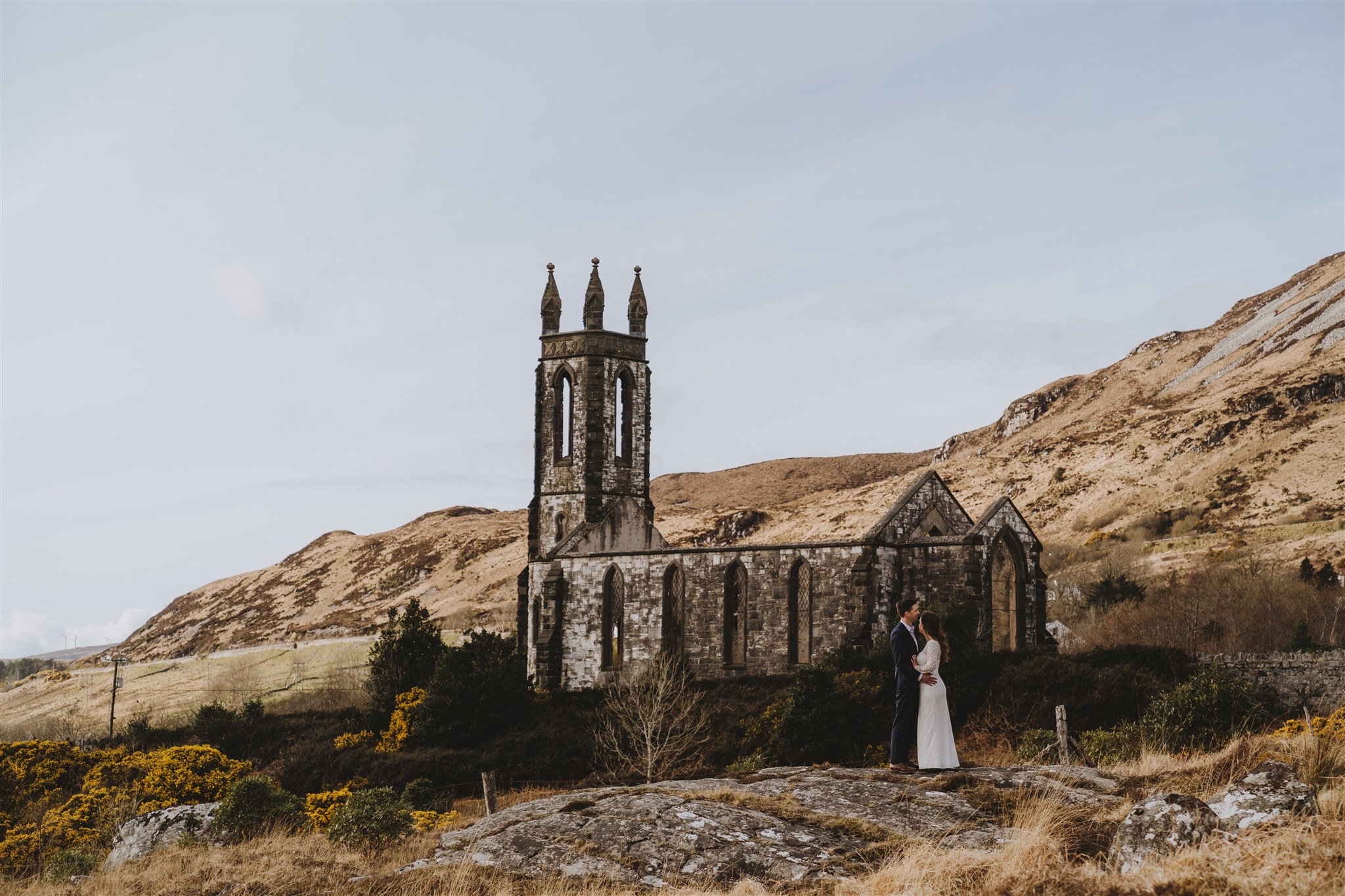 Couple eloping beside an ancient stone church ruin in the Irish countryside during an intimate Ireland destination wedding