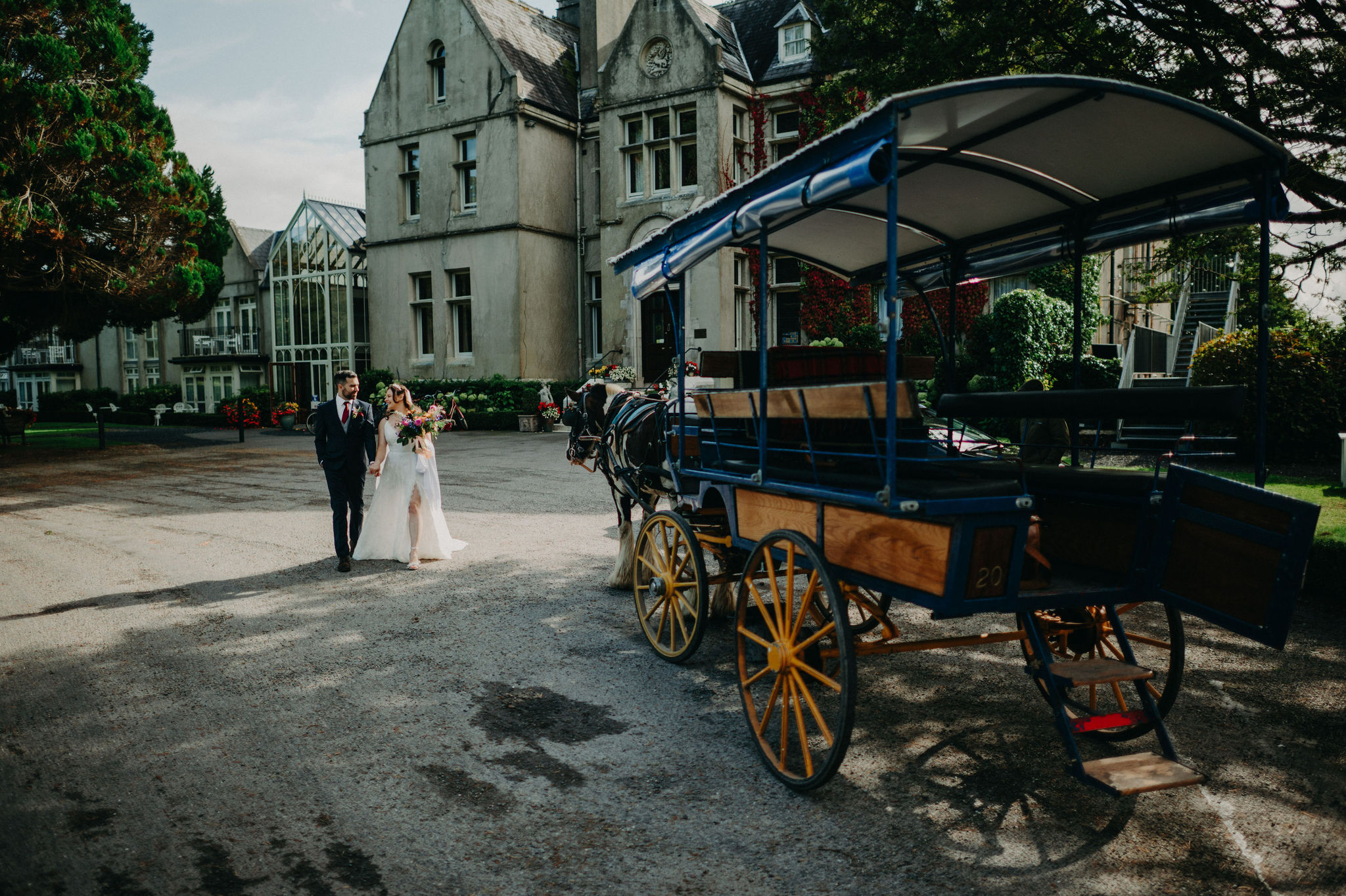 Couple walking beside carriage outside Cahernane House Ireland