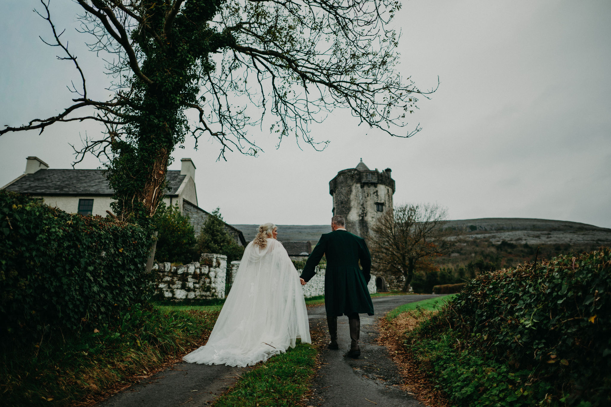 Couple walking beside Newtown Castle during an elopement wedding in Ireland.