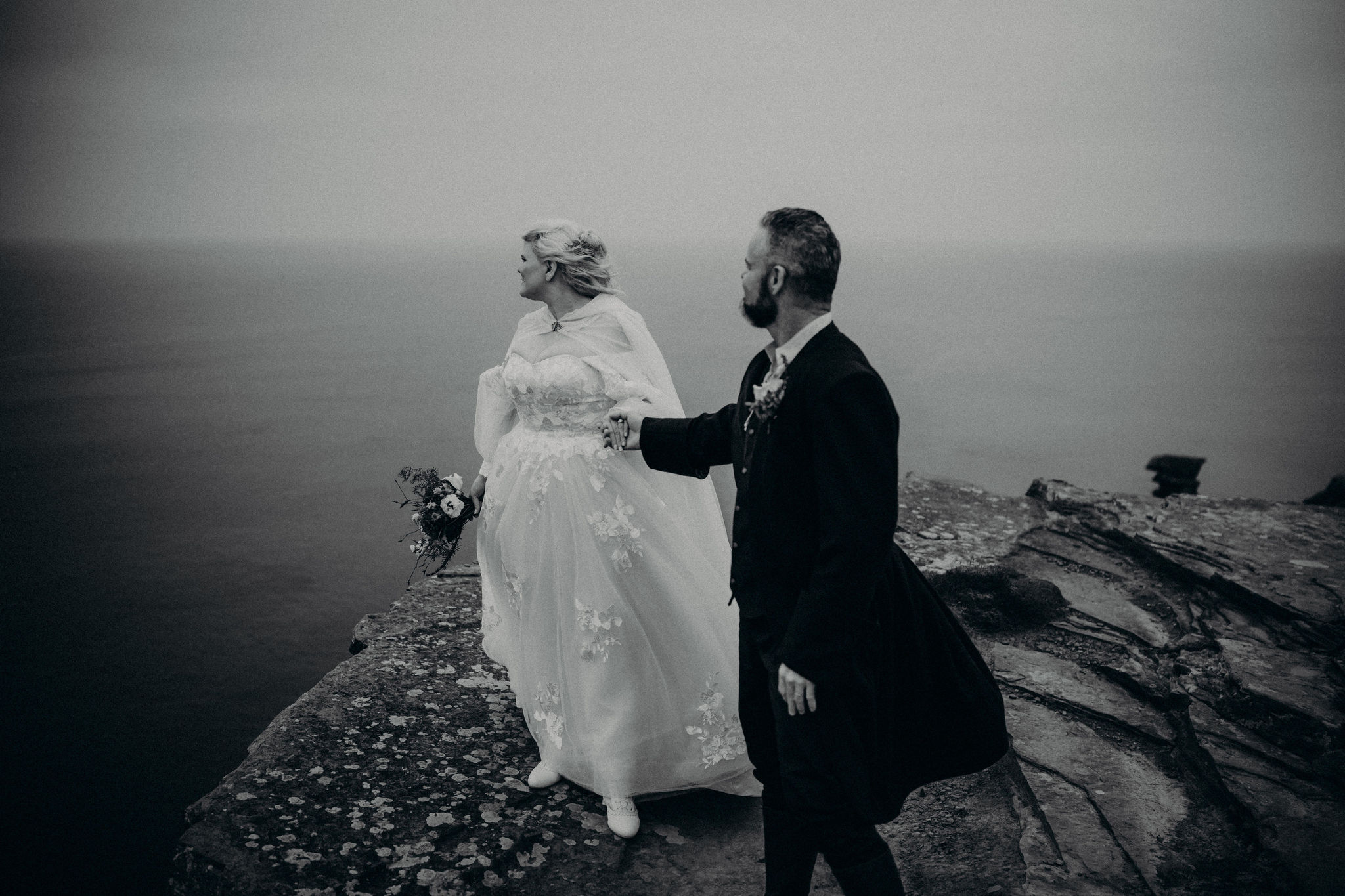 Bride and groom standing at Hags Head Cliffs of Moher during Ireland elopement.