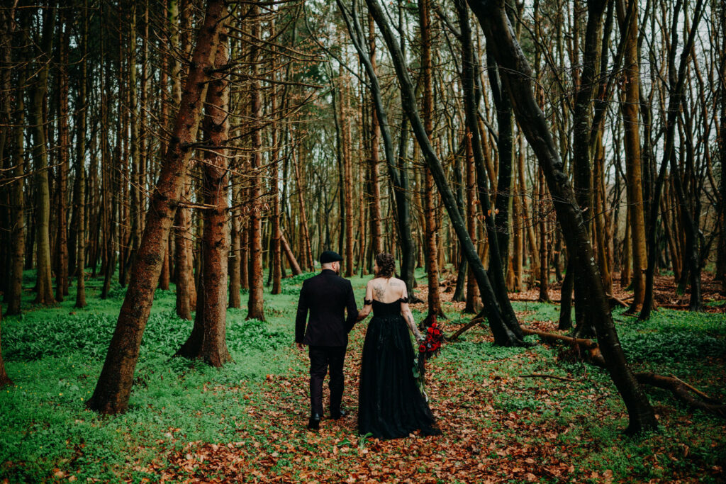 Couple walking hand in hand through a forest during an intimate Ireland elopement