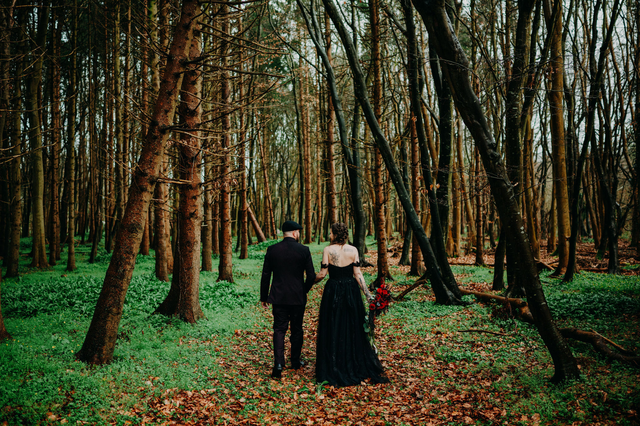 Couple walking hand in hand through a forest during an intimate Ireland elopement