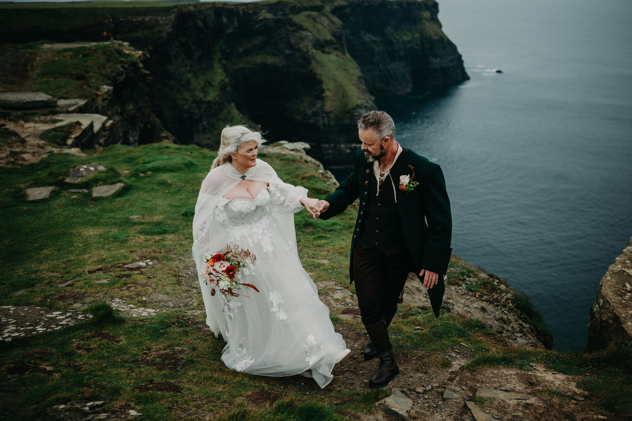 Couple walking near the Cliffs of Moher at Hags Head during Ireland destination wedding.