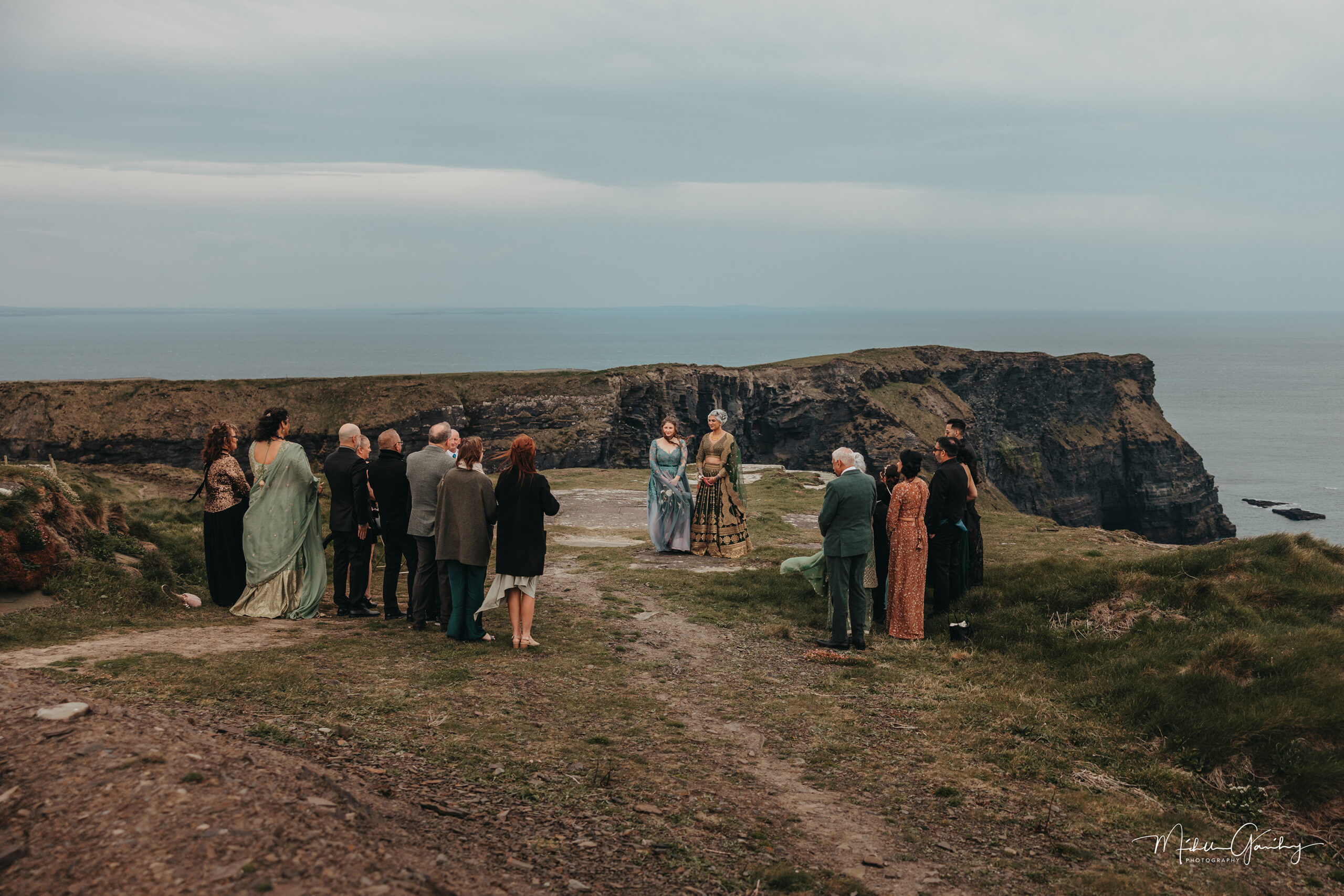 Same-sex elopement ceremony with guests at the Cliffs of Moher in Ireland.