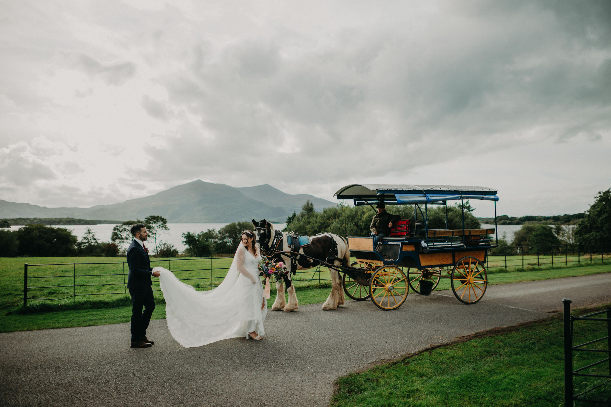 Bride and groom beside horse carriage with mountain views in Killarney National Park