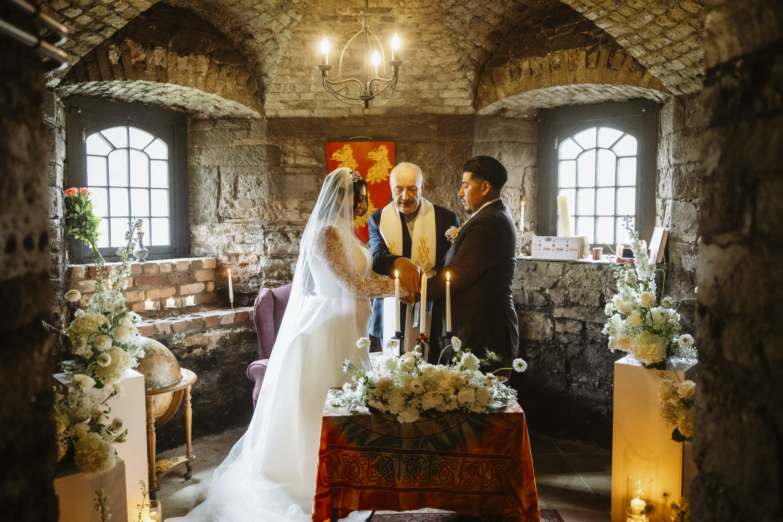 Bride and groom exchanging vows during an intimate candlelit wedding ceremony inside Kinnitty Castle in Ireland.