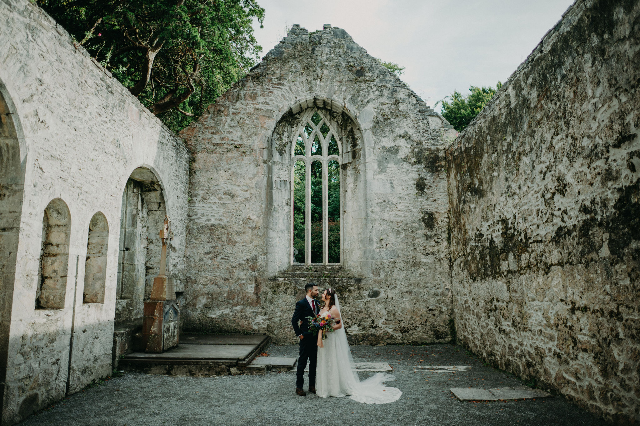 Couple kissing inside ruined chapel at Muckross Abbey Ireland