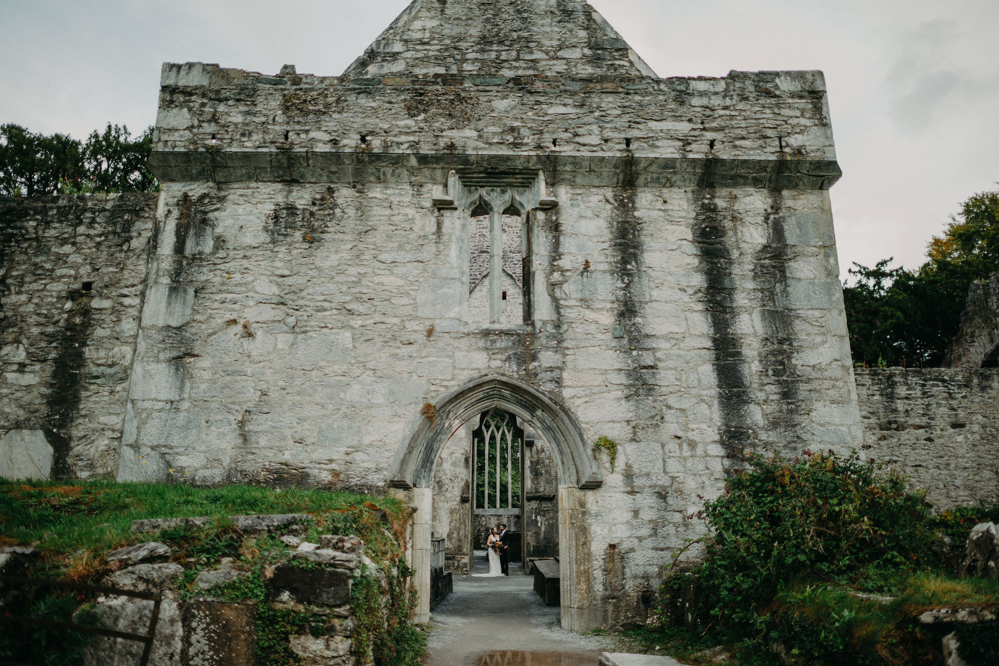 Couple framed through ancient entrance at Muckross Abbey during Ireland elopement