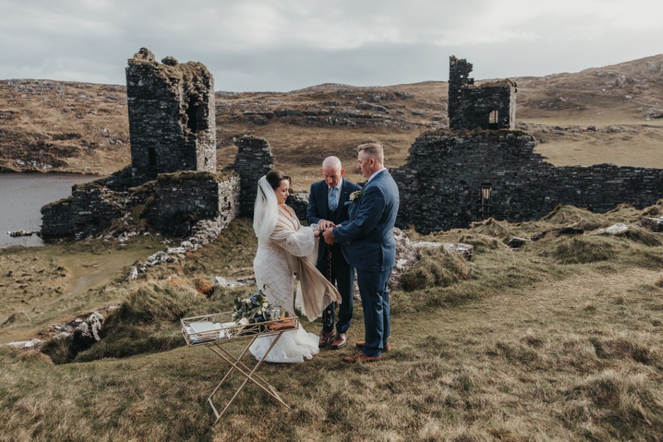 Celtic handfasting ceremony during an intimate Ireland elopement beside historic ruins and lakeside views.