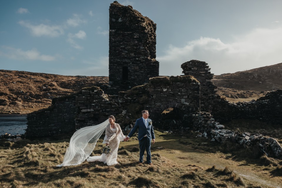 Irish castle ruins elopement photography featuring a dramatic long bridal veil.