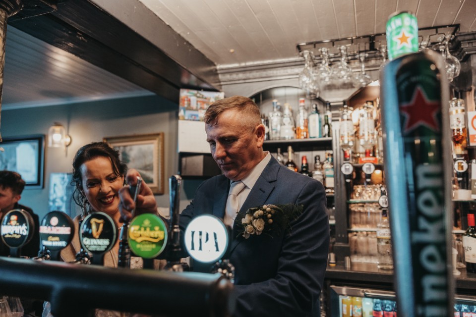 Couple pulling a pint during an Irish pub elopement celebration.