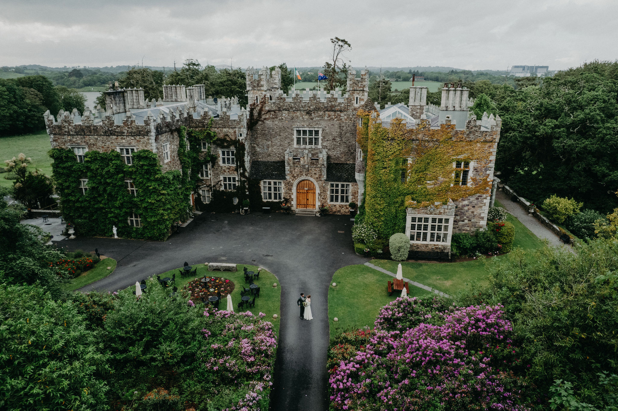 Aerial view of a couple standing in front of Waterford Castle during their destination elopement wedding in Ireland.