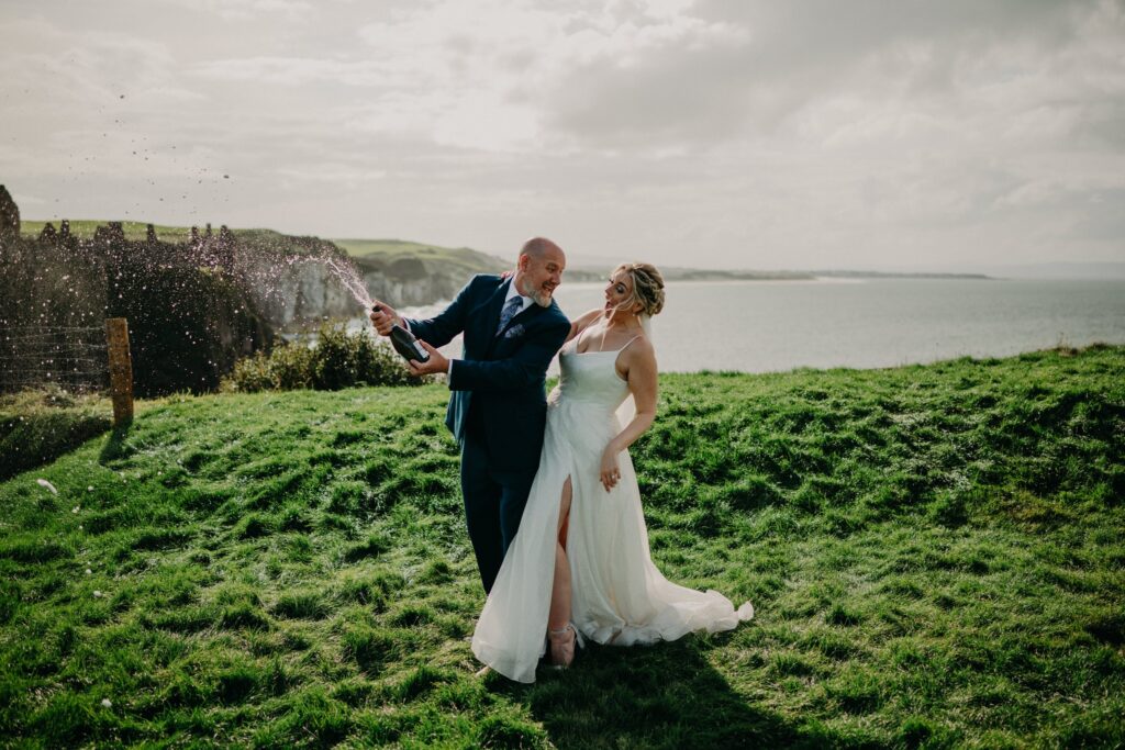 Bride and groom celebrating their Dunluce Castle wedding on the Causeway Coast in Northern Ireland