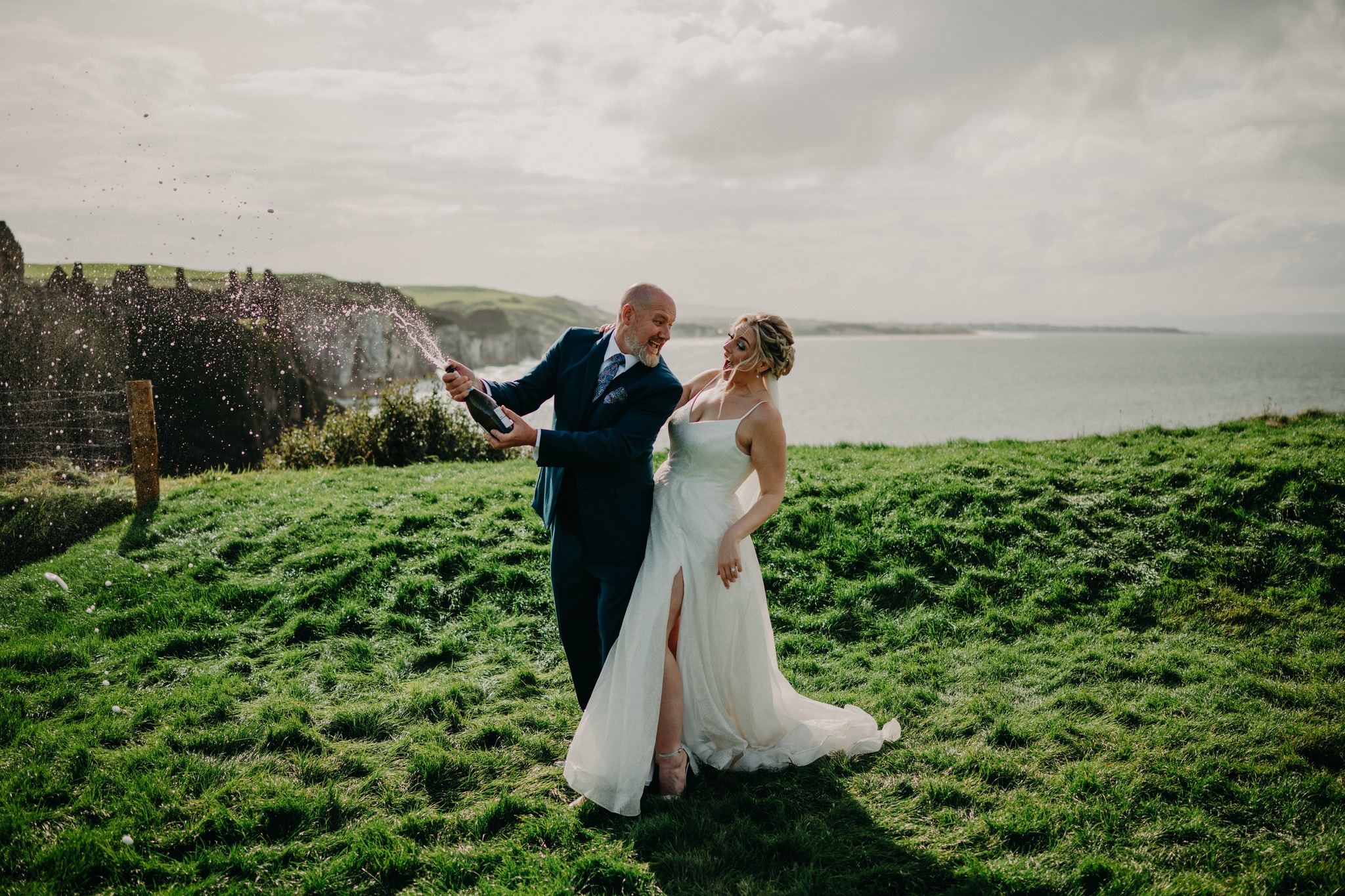 Bride and groom celebrating their Dunluce Castle wedding on the Causeway Coast in Northern Ireland