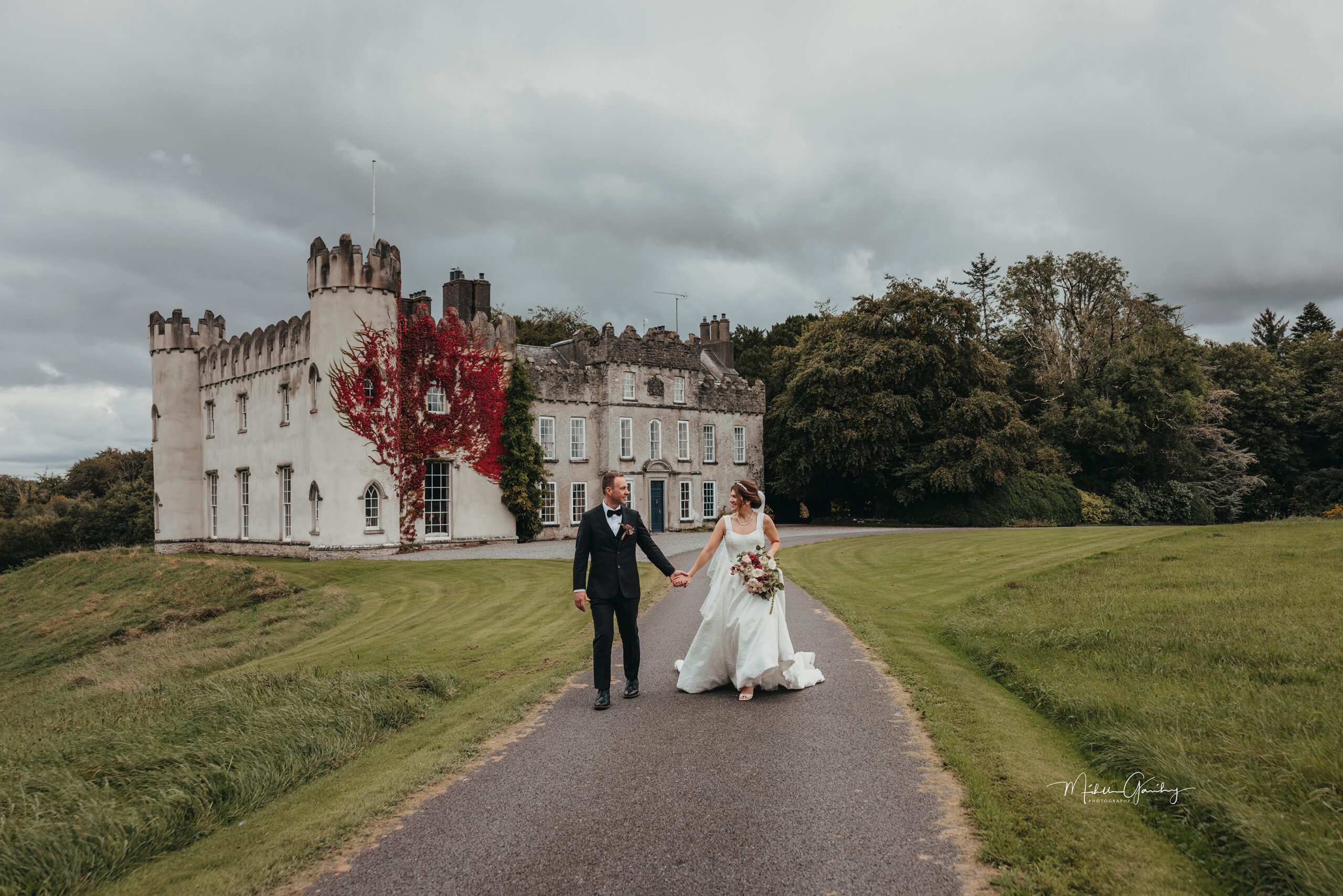 Couple walking outside an Irish castle on their wedding day
